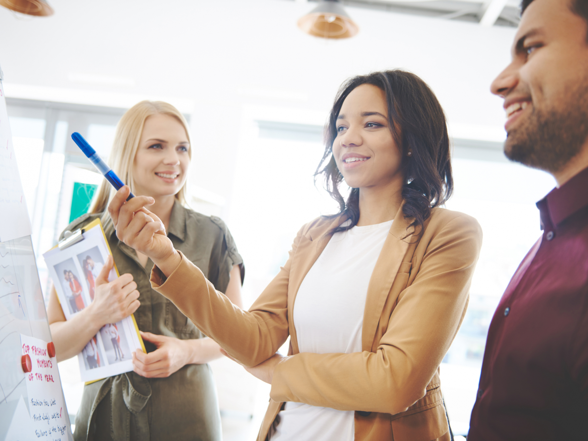 Woman explaining business strategy to coworkers. Cover magazine visable on the picture and property release including